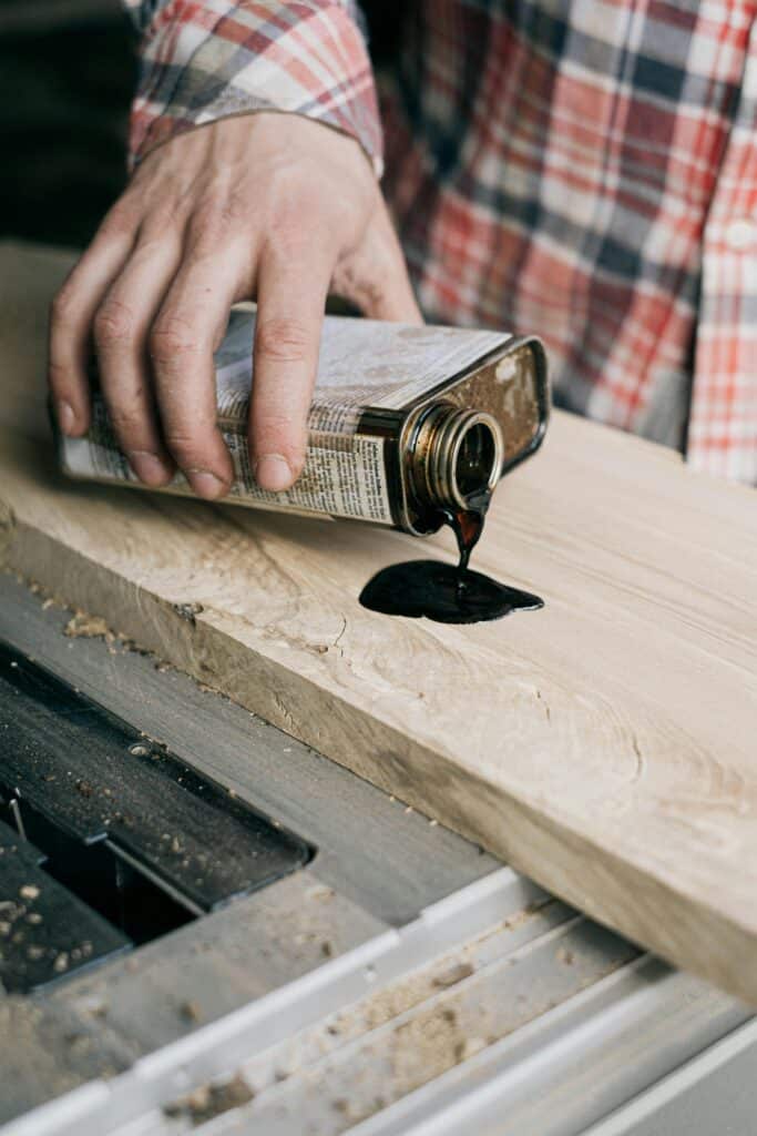 pexels-photo-4491884-4491884 A craftsman applies varnish to a wooden plank, showcasing woodworking skills.